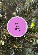 Load image into Gallery viewer, light purple, 1.5&#39;, round sticker with white border and black message, see the love, with a small black heart at the bottom right of the letters 
